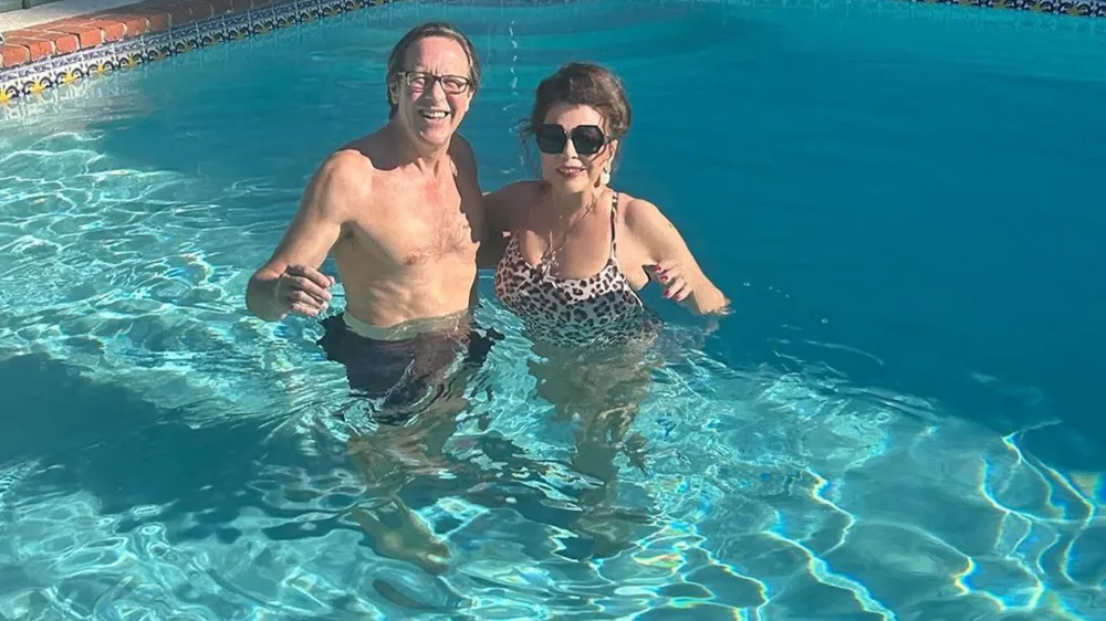 Joan Collins, zvezdnica kultne telenovele iz 80. let prejšnjega stoletja Dinastija, v kateri je igrala spletkarsko Alexis, je danes stara 89, te dni pa je ob praznovanju božiča pokazala, da je še vedno v odlični formi. Na družbenih omrežkih je objavila fotografije z zabave na Beverly Hillsu, kjer si je za kopanje v bazeni izbrala enodelne kopalke z leopardjim vzorcem in razkrila izjemno postavo. Fotografija, na kateri je z možem Percyjem Gibsonom, ki je od nje mlajši 32 let