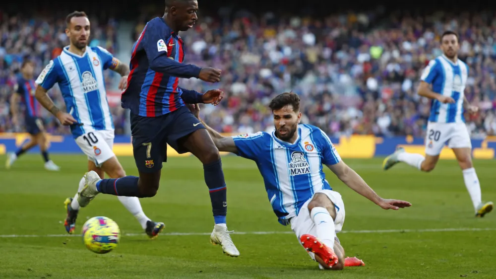 Barcelona's Ousmane Dembele, 2nd left is tackled by Espanyol's Leandro Cabrera during a Spanish La Liga soccer derby match between Barcelona and Espanyol at the Camp Nou stadium in Barcelona, Spain, Saturday, Dec. 31, 2022. (AP Photo/Joan Monfort)