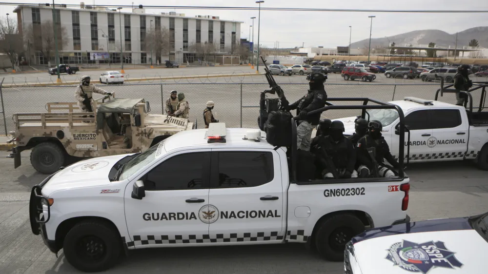 Mexican National Guard stand guard outside a state prison in Ciudad Juarez, Mexico, Sunday Jan 1, 2023. Mexican soldiers and state police regained control of a state prison in Ciudad Juarez across the border from El Paso, Texas after violence broke out early Sunday, according to state officials. (AP Photo/Christian Chavez)