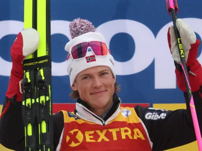 03 January 2023, Bavaria, Oberstdorf: Norway's winner Johannes Hosflot Klaebo celebrates on the podium after the Men's Interval Start 10.0 km Classic race of the Tour de Ski in Oberstdorf. Photo: Karl-Josef Hildenbrand/dpa