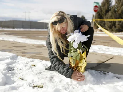 Sharon Huntsman, a member of The Church of Jesus Christ of Latter-day Saints from Cedar City, Utah, leaves flowers outside a home where eight family members were found dead in Enoch, Utah, Thursday, Jan. 5, 2023. Officials said Michael Haight, 42, took his own life after killing his wife, mother-in-law and the couple's five children. (Ben B. Braun/The Deseret News via AP)