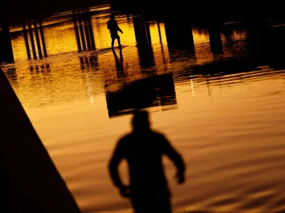 Asylum-seeking migrants cross the Rio Bravo river, the border between the United States and Mexico, to request asylum in El Paso, Texas, U.S., as seen from Ciudad Juarez, Mexico December 21, 2022. REUTERS/Jose Luis Gonzalez   TPX IMAGES OF THE DAY