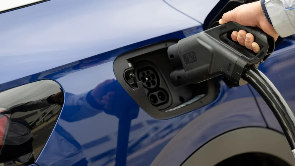 FILED - 14 July 2022, Saxony, Zwickau: A person connects an all-electric ID.4 to a charging station at a Volkswagen plant. Photo: Hendrik Schmidt/dpa