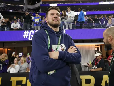 Dallas Maverics player Luka Doncic watches teams warm up before the national championship NCAA College Football Playoff game between Georgia and TCU, Monday, Jan. 9, 2023, in Inglewood, Calif. (AP Photo/Ashley Landis)