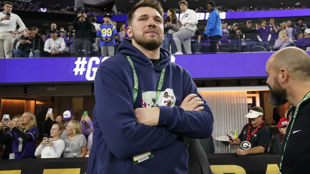 Dallas Maverics player Luka Doncic watches teams warm up before the national championship NCAA College Football Playoff game between Georgia and TCU, Monday, Jan. 9, 2023, in Inglewood, Calif. (AP Photo/Ashley Landis)