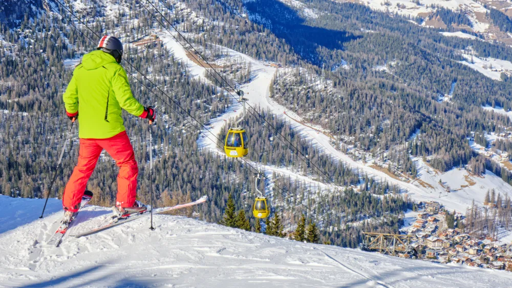 Alta Badia, Italy - January 21, 2020: Skier preparing to drop into a red ski run above La Villa village, South Tyrol, in Dolomites, Italy.