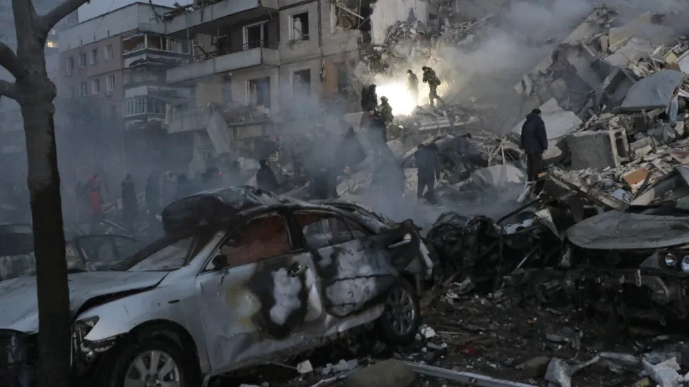 Emergency workers clear the rubble after a Russian rocket hit a multistory building leaving many people under debris in Dnipro, Ukraine, Saturday, Jan. 14, 2023. (AP Photo/Roman Chop)