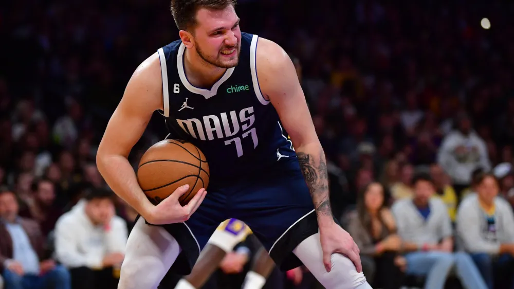 Jan 12, 2023; Los Angeles, California, USA; Dallas Mavericks guard Luka Doncic (77) gets the rebound against the Los Angeles Lakers during the second half at Crypto.com Arena. Mandatory Credit: Gary A. Vasquez-USA TODAY Sports