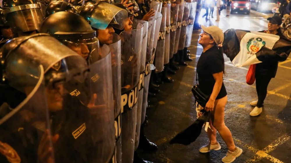 A demonstrator reacts before security forces as people protest demanding the dissolution of Congress and democratic elections, in rejection of Dina Boluarte as Peru's president, after the ouster of leftist President Pedro Castillo, in Lima, Peru January 12, 2023. REUTERS/Sebastian Castaneda