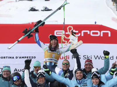 Slovenia's Ilka Stuhec celebrates with her team after winning an alpine ski, women's World Cup downhill race, in Cortina d'Ampezzo, Italy, Saturday, Jan. 21, 2023. (AP Photo/Alessandro Trovati)