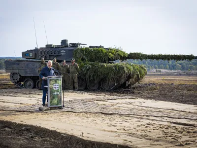 FILE - German Chancellor Olaf Scholz speaks to soldiers in front of a Leopard 2 main battle tank after the Army's training and instruction exercise in Ostenholz, Germany, Monday, oct. 17, 2022. Germany has become one of Ukraine's leading weapons suppliers in the 11 months since Russia's invasion. The debate among allies about the merits of sending battle tanks to Ukraine has focused the spotlight relentlessly on Germany, whose Leopard 2 tank is used by many other countries and has long been sought by Kyiv. (Moritz Frankenberg/dpa via AP, FILE)