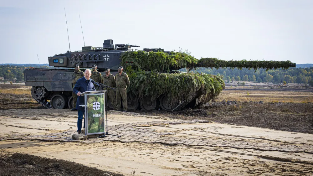 FILE - German Chancellor Olaf Scholz speaks to soldiers in front of a Leopard 2 main battle tank after the Army's training and instruction exercise in Ostenholz, Germany, Monday, oct. 17, 2022. Germany has become one of Ukraine's leading weapons suppliers in the 11 months since Russia's invasion. The debate among allies about the merits of sending battle tanks to Ukraine has focused the spotlight relentlessly on Germany, whose Leopard 2 tank is used by many other countries and has long been sought by Kyiv. (Moritz Frankenberg/dpa via AP, FILE)
