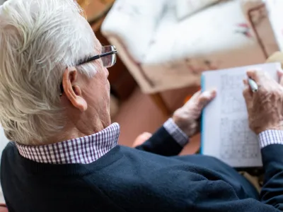 Senior Man Doing Sudoku Puzzle At Home