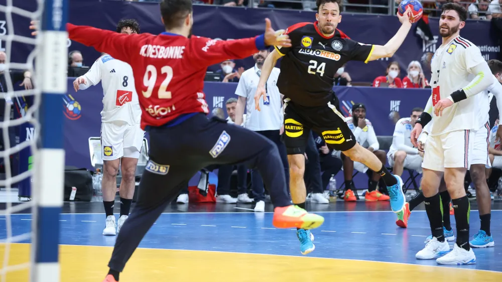 25 January 2023, Poland, Danzig: Germany's Patrick Groetzki throws against France's goalkeeper Remi Desbonnet during the Handball World Cup quarterfinal match between France and Germany at the Ergo Arena Photo: Jan Woitas/dpa