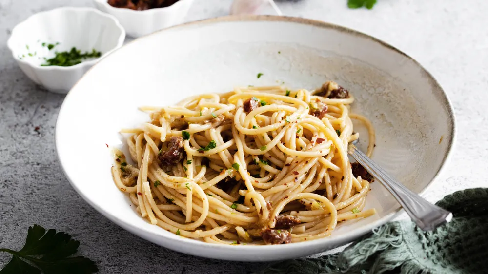 Špageti s pečenim česnom in sušenimi paradižniki