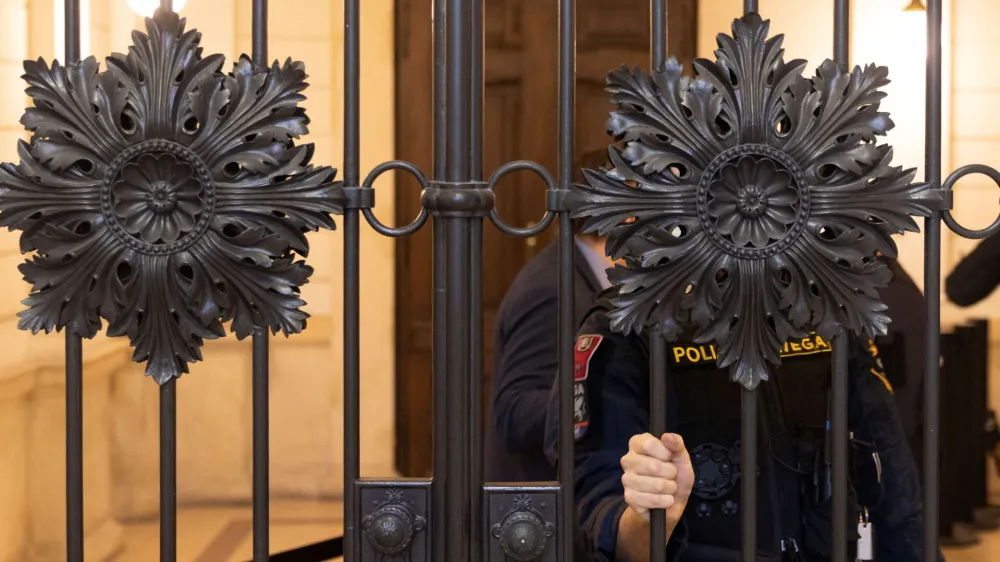 An Austrian police officer waits outside the courtroom as the verdict for six men accused of providing various degrees of help to a jihadist who killed four people in a shooting rampage in Vienna in November 2020 is expected, in Vienna, Austria, February 1, 2023. REUTERS/Lisa Leutner