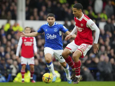 Arsenal's William Saliba, right, challenges for the ball with Everton's Neal Maupay during the English Premier League soccer match between Everton and Arsenal at Goodison Park in Liverpool, England, Saturday, Feb. 4, 2023. (AP Photo/Jon Super)