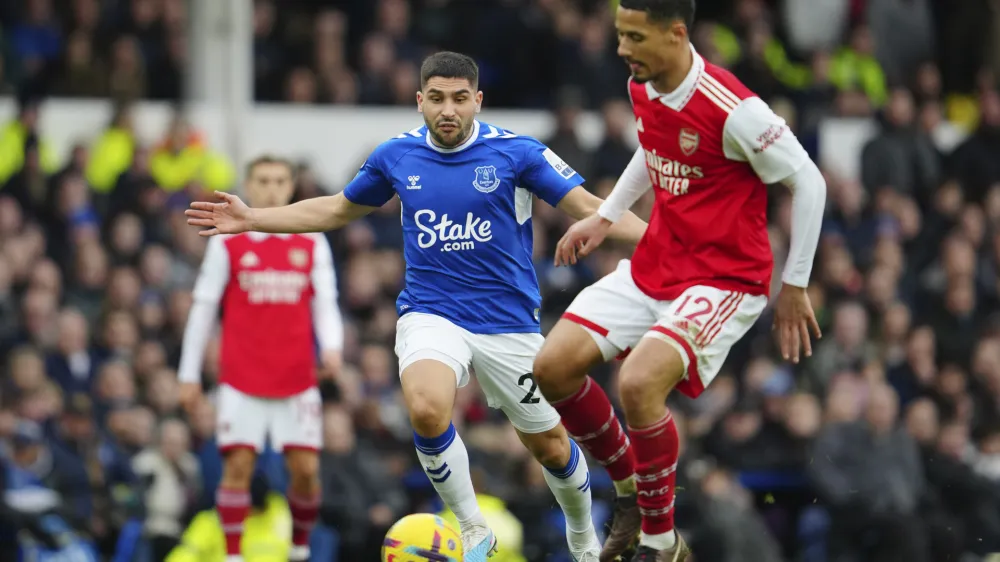 Arsenal's William Saliba, right, challenges for the ball with Everton's Neal Maupay during the English Premier League soccer match between Everton and Arsenal at Goodison Park in Liverpool, England, Saturday, Feb. 4, 2023. (AP Photo/Jon Super)