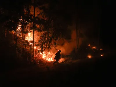 A firefighter fights flames caused by wildfires in Puren, Chile, Saturday, Saturday, Feb. 4, 2023. Forest fires are spreading in southern and central Chile, triggering evacuations and the declaration of a state of emergency in some regions. (AP Photo/Matias Delacroix)