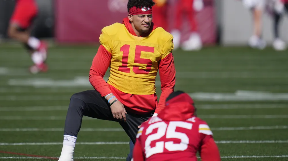 Kansas City Chiefs quarterback Patrick Mahomes (15) stretches with teammates, including running back Clyde Edwards-Helaire (25), during an NFL football practice in Tempe, Ariz., Wednesday, Feb. 8, 2023. The Chiefs will play against the Philadelphia Eagles in Super Bowl 57 on Sunday. (AP Photo/Ross D. Franklin)