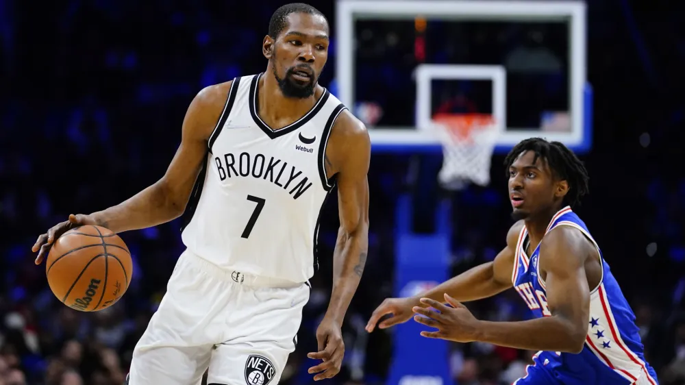 ﻿Brooklyn Nets' Kevin Durant, left, dribbles past Philadelphia 76ers' Tyrese Maxey during the second half of an NBA basketball game, Thursday, March 10, 2022, in Philadelphia. (AP Photo/Matt Slocum)