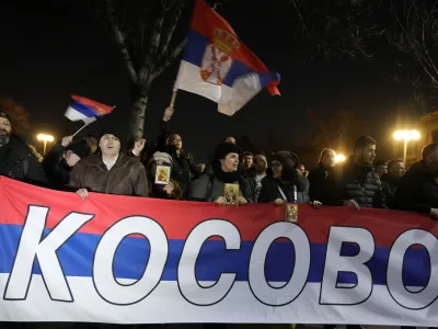 People hold a Serbian flag reading "Kosovo" during a protest against the Serbian authorities and French-German plan for the resolution of Kosovo, in Belgrade, Serbia, Wednesday, Feb. 15, 2023. Hundreds of pro-Russia nationalists have rallied outside the Serbian presidency building demanding that President Aleksandar Vucic reject a Western plan for normalization of ties with breakaway Kosovo and pull out of negotiations. Shouting "Treason" and carrying banners reading "No surrender," the protesters on Wednesday blocked traffic in a busy street by the presidency. (AP Photo/Darko Vojinovic)