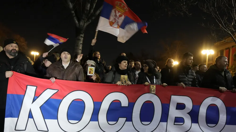 People hold a Serbian flag reading "Kosovo" during a protest against the Serbian authorities and French-German plan for the resolution of Kosovo, in Belgrade, Serbia, Wednesday, Feb. 15, 2023. Hundreds of pro-Russia nationalists have rallied outside the Serbian presidency building demanding that President Aleksandar Vucic reject a Western plan for normalization of ties with breakaway Kosovo and pull out of negotiations. Shouting "Treason" and carrying banners reading "No surrender," the protesters on Wednesday blocked traffic in a busy street by the presidency. (AP Photo/Darko Vojinovic)