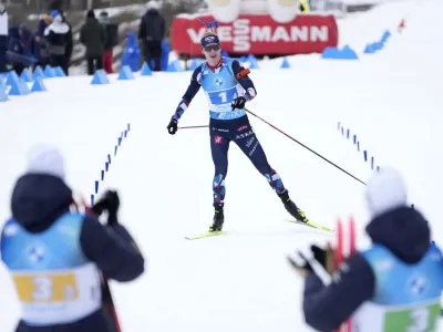 French Athletes in the foreground applaud as Johannes Thingnes Boe, of Norway, approaches the finish line to win the silver medal in the Men 4 X 7.5 km Relay event at the Biathlon World Championships in Oberhof, Germany, Saturday, Feb. 18, 2023. (AP Photo/Matthias Schrader)