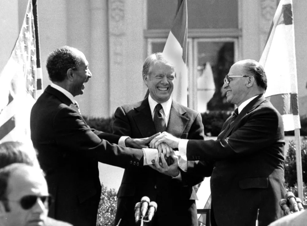 Egyptian President Anwar Sadat, left, U.S. President Jimmy Carter, center, and Israeli Prime Minister Menachem Begin clasp hands on the north lawn of the White House after signing the peace treaty between Egypt and Israel on March 26, 1979. Sadat and Begin were awarded the Nobel Peace Prize for accomplishing peace negotiations in 1978. The rest of the Arab world shunned Sadat, condemning his initiative for peace. President Carter was pivotol for the two leaders to meet at Camp David and as a result, peace began between Arabs and Jews. (AP Photo/ Bob Daugherty)