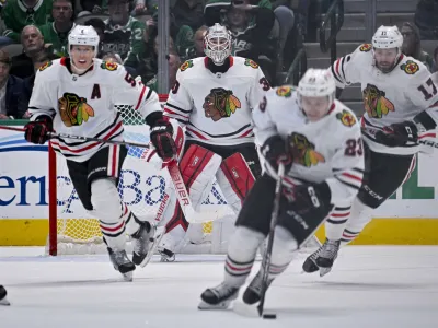 Feb 22, 2023; Dallas, Texas, USA; Chicago Blackhawks goaltender Jaxson Stauber (30) watches as defenseman Connor Murphy (5) and center Philipp Kurashev (23) and center Jason Dickinson (17) carry the puck up the ice against the Dallas Stars during the third period at the American Airlines Center. Mandatory Credit: Jerome Miron-USA TODAY Sports