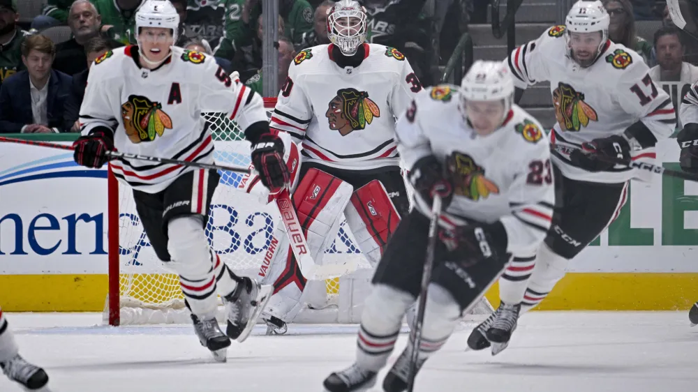 Feb 22, 2023; Dallas, Texas, USA; Chicago Blackhawks goaltender Jaxson Stauber (30) watches as defenseman Connor Murphy (5) and center Philipp Kurashev (23) and center Jason Dickinson (17) carry the puck up the ice against the Dallas Stars during the third period at the American Airlines Center. Mandatory Credit: Jerome Miron-USA TODAY Sports