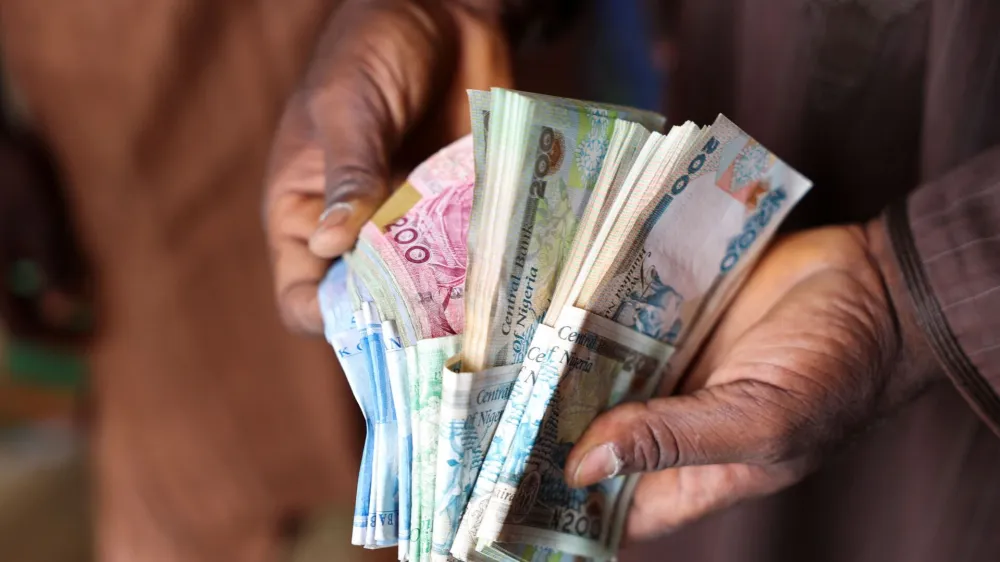 A man counts Nigerian naira notes in a market place as people struggle with the economic hardship and cashflow problems ahead of Nigeria's Presidential elections, in Yola, Nigeria, February 22, 2023. REUTERS/Esa Alexander