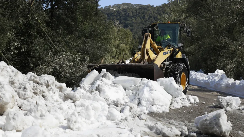 01 March 2023, Spain, Escora: A heavy wheel loader pushes snow from the road in the Escora pilgrimage site near the monastery of Lluc. Mallorca has requested the help of the Spanish military emergency aid unit as it struggles to deal with a storm that brought more than 1 metre of snow to the island. Photo: Clara Margais/dpa