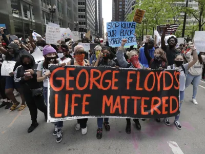 FILE - Protesters hold signs as they march during a protest over the death of George Floyd in Chicago on May 30, 2020. Two former Minneapolis police officers charged in Floyd's death are heading to trial on state aiding and abetting counts, the third and likely final criminal proceeding in a killing that mobilized protesters worldwide against racial injustice in policing. (AP Photo/Nam Y. Huh, File)