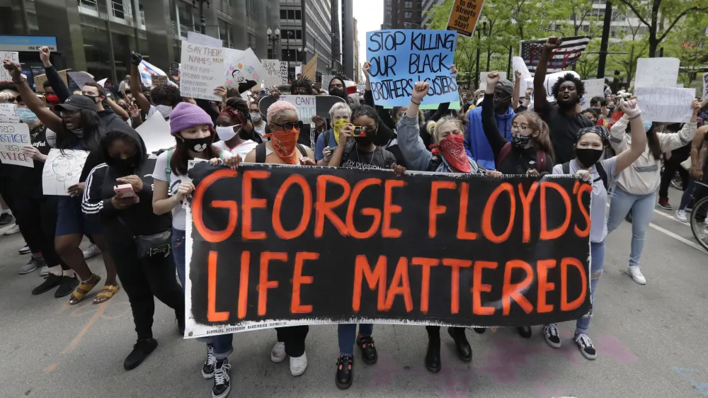 FILE - Protesters hold signs as they march during a protest over the death of George Floyd in Chicago on May 30, 2020. Two former Minneapolis police officers charged in Floyd's death are heading to trial on state aiding and abetting counts, the third and likely final criminal proceeding in a killing that mobilized protesters worldwide against racial injustice in policing. (AP Photo/Nam Y. Huh, File)