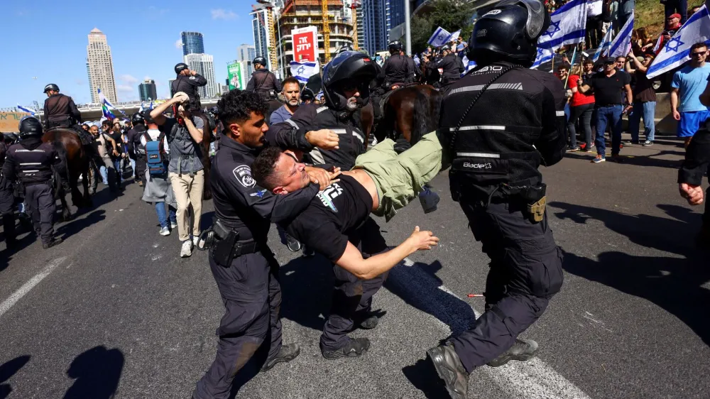 Israeli police officers detain a demonstrator during "Day of Resistance", as Israeli Prime Minister Benjamin Netanyahu's nationalist coalition government presses on with its contentious judicial overhaul, in Tel Aviv, Israel March 9, 2023. REUTERS/Ronen Zvulun   TPX IMAGES OF THE DAY