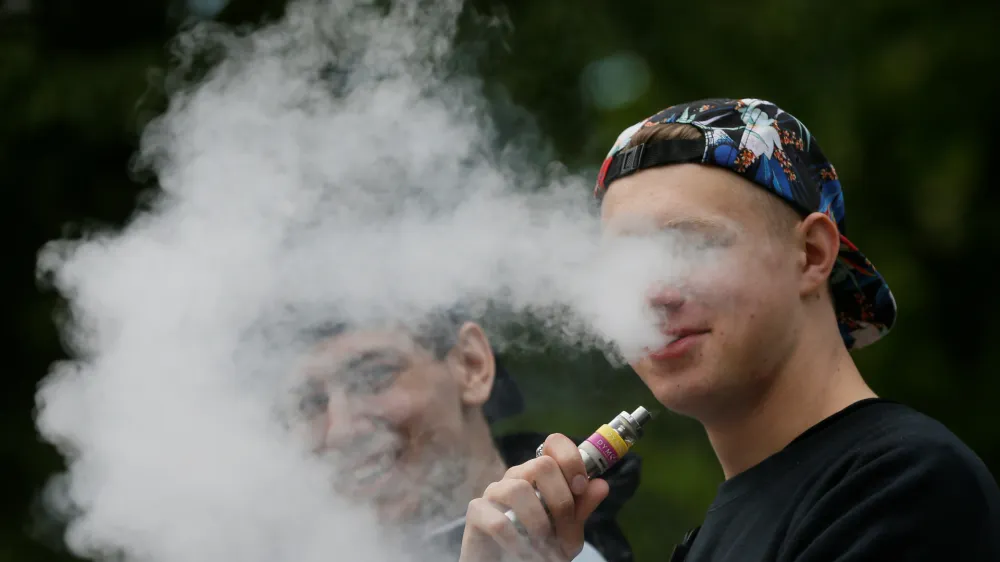A man exhales electronic cigarette vapour in a park in central Kiev, Ukraine May 12, 2017. REUTERS/Valentyn Ogirenko - RC1445F0D830