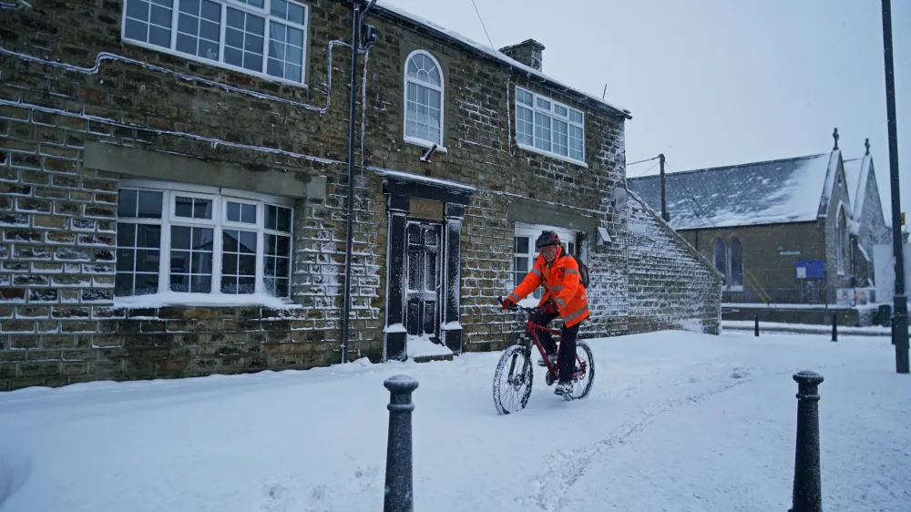 10 March 2023, United Kingdom, Tow Law: A cyclist makes their way through a snow-covered road in Tow Law, Co Durham, after a heavy overnight snowfall. Photo: Owen Humphreys/PA Wire/dpa