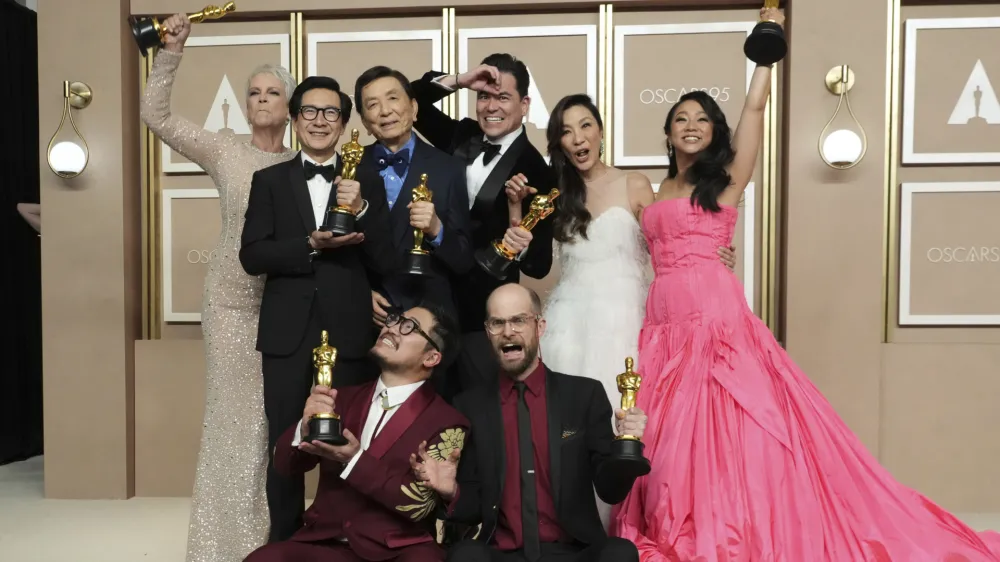 Jamie Lee Curtis, from back left, Ke Huy Quan, James Hong, Jonathan Wang, Michelle Yeoh, and Stephanie Hsu, Daniel Kwan, left front, and Daniel Scheinert, winners of the award for best film for "Everything Everywhere All at Once," pose in the press room at the Oscars on Sunday, March 12, 2023, at the Dolby Theatre in Los Angeles. (Photo by Jordan Strauss/Invision/AP)