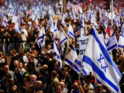 People hold Israeli flags during a demonstration as Israeli Prime Minister Benjamin Netanyahu's nationalist coalition government presses on with its contentious judicial overhaul, in Tel Aviv, Israel, March 11, 2023. REUTERS/Nir Elias