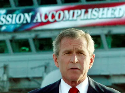 FILE PHOTO: The White House said on October 29, 2003 that it had helped with the production of a "Mission Accomplished" banner as a backdrop for President George W. Bush's speech onboard the USS Abraham Lincoln to declare combat operations over in Iraq. This file photo shows Bush delivering a speech to crew aboard the aircraft carrier USS Abraham Lincoln, as the carrier steamed toward San Diego, California on May 1, 2003. REUTERS/Larry Downing/FILE  KL/GN/GAC/File Photo