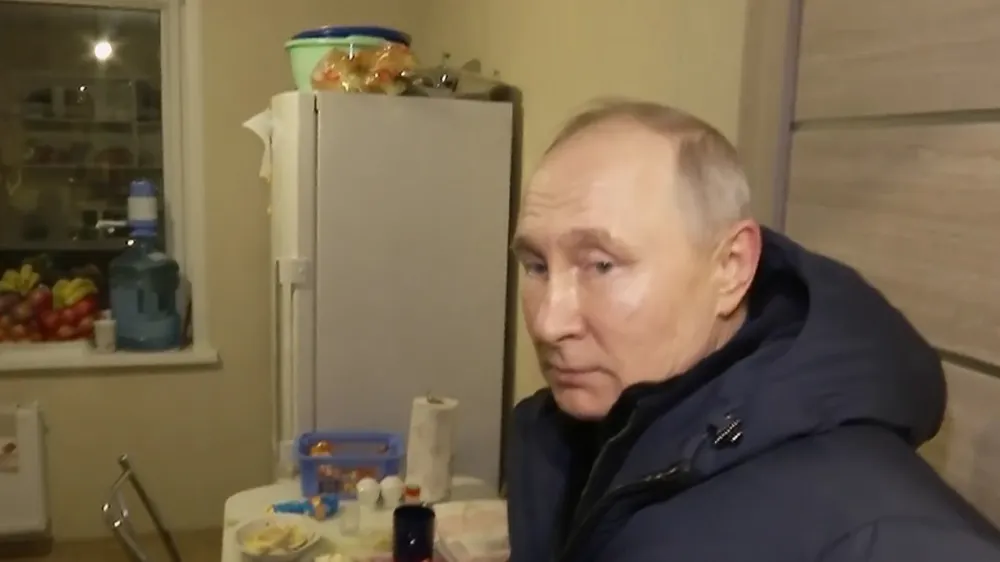 In this photo taken from video released by Russian TV Pool on Sunday, March 19, 2023, Russian President Vladimir Putin listens to local residents at their new flat during his visit to Mariupol in Russian-controlled Donetsk region, Ukraine. Putin has traveled to Crimea to mark the ninth anniversary of the Black Sea peninsula's annexation from Ukraine. (Pool Photo via AP)