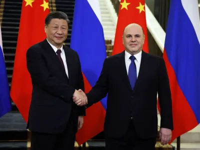Russian Prime Minister Mikhail Mishustin shakes hands with Chinese President Xi Jinping during a meeting in Moscow, Russia March 21, 2023. Sputnik/Dmitry Astakhov/Pool via REUTERS ATTENTION EDITORS - THIS IMAGE WAS PROVIDED BY A THIRD PARTY.