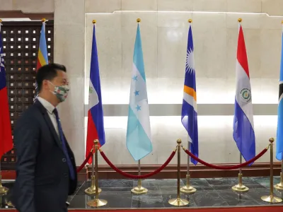 A man walks in front of flags of Honduras, Taiwan, and other countries, displayed at the Ministry of Foreign Affairs building, in Taipei, Taiwan March 23, 2023. REUTERS/Annabelle Chih