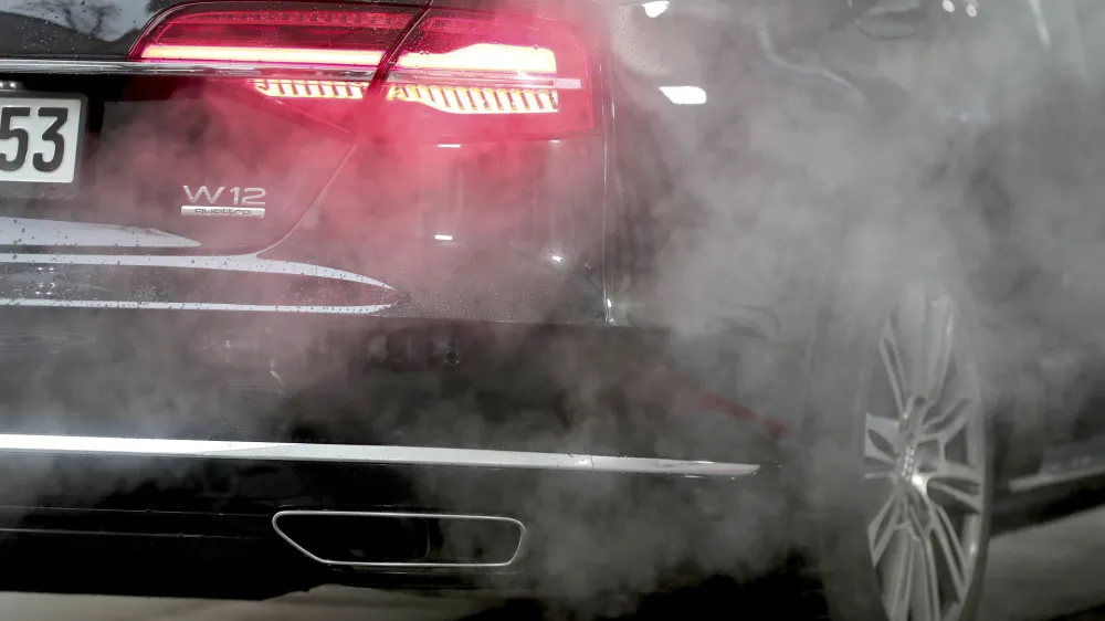 FILE - A luxury Audi car is surrounded by exhaust gases as it is parked with a running engine in front of the Chancellery in Berlin, Germany, Wednesday, Nov. 20, 2019. Germany's transport minister said Tuesday that his country won't back a planned European Union ban on the sale of new cars with combustion engines from 2035. (AP Photo/Michael Sohn, File)