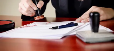 Closeup on notary's public hands stamping document. Notary public accessories