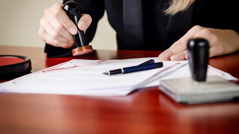 Closeup on notary's public hands stamping document. Notary public accessories