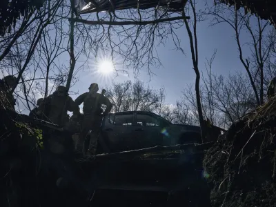 Ukrainian soldiers of the 28th brigade gather near a trench on the frontline during a battle with Russian troops near Bakhmut, Donetsk region, Ukraine, Monday, March 27, 2023. (AP Photo/Libkos)
