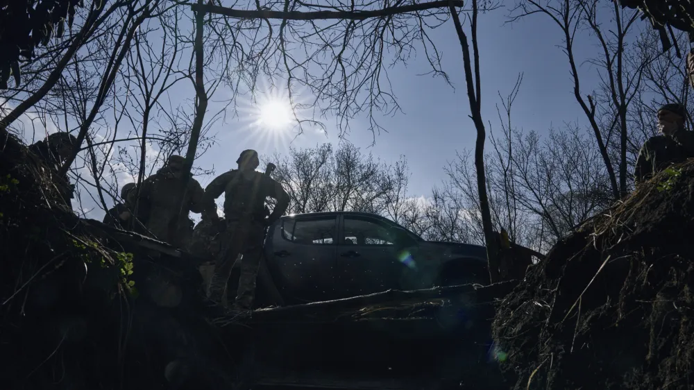Ukrainian soldiers of the 28th brigade gather near a trench on the frontline during a battle with Russian troops near Bakhmut, Donetsk region, Ukraine, Monday, March 27, 2023. (AP Photo/Libkos)