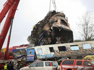 A crane lifts parts of a destroyed carriage as rescuers operate on the site of a crash, where two trains collided, near the city of Larissa, Greece, March 2, 2023. REUTERS/Kostas Mantziaris NO RESALES. NO ARCHIVES   TPX IMAGES OF THE DAY